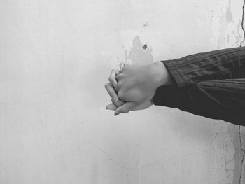 Midsection of person standing against wall