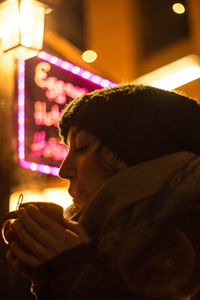 Portrait of man holding illuminated lamp