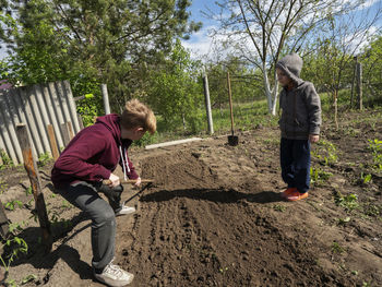 Brothers playing in dirt at yard