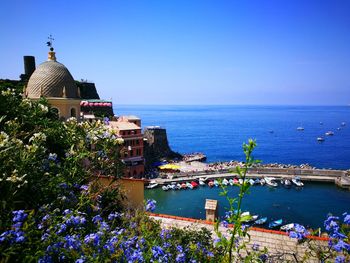 Scenic view of sea by buildings against blue sky