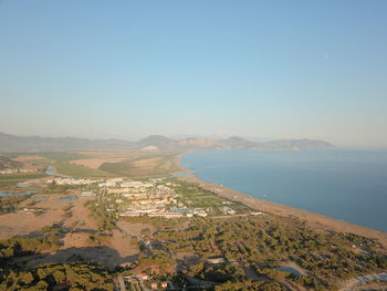 Aerial view of townscape by sea against clear sky