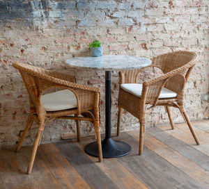 Empty chairs and table against wall at home