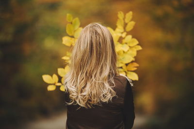 Rear view of woman standing at park during autumn