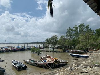 Sailboats moored on river against sky