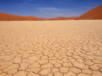 Cracked landscape against sky at desert