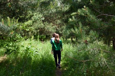 Rear view of women walking in forest