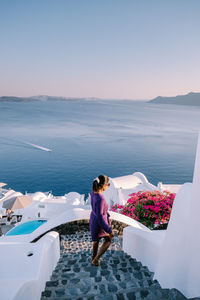 Woman standing on sea against sky