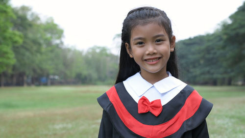 Portrait of smiling girl standing on field