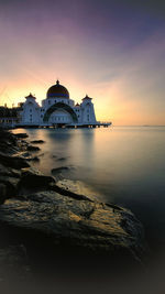 View of sea and buildings against sky during sunset