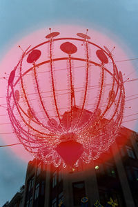 Low angle view of illuminated ferris wheel against sky in city