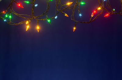 Low angle view of illuminated christmas lights at night