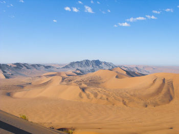 Scenic view of desert against blue sky