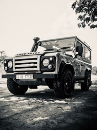 Abandoned car on field against clear sky