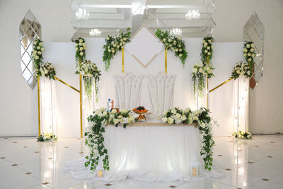 Wedding table of the bride and groom decorated with flowers and greenery on a white background.