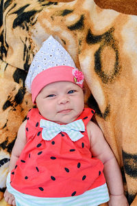 Close-up portrait of a 2-month-old newborn girl of caucasian race on a towel outdoors.