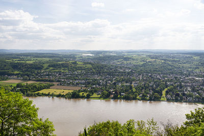 River rhein in western germany flowing along the city against the sky with clouds. visible ships.