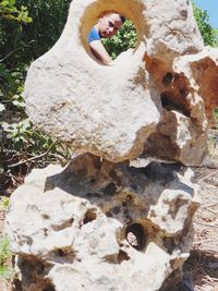 High angle view of boy relaxing on rock