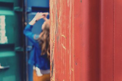 Rear view of woman amidst cargo containers