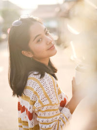 Portrait of beautiful young woman standing outdoors