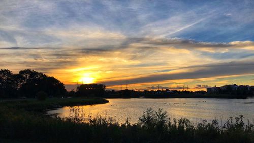 Scenic view of lake against orange sky