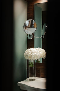 Close-up of flower vase on table against wall at home