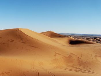 Sand dunes against blue sky