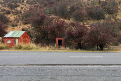 Road by trees against built structure