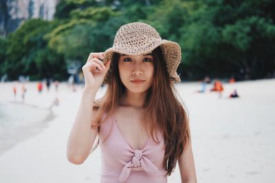 Portrait of young woman wearing hat standing outdoors