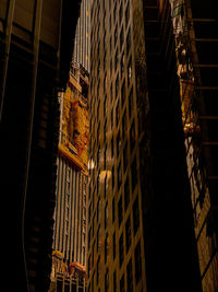 Low angle view of illuminated lights hanging in building at night