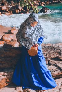 Woman in hijab standing on rock