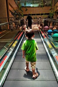 Rear view of man and woman walking in shopping mall