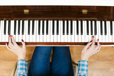Low section of woman playing piano