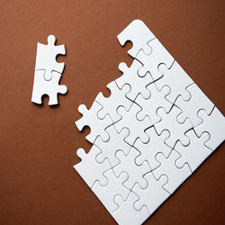 Close-up of white jigsaw pieces on table