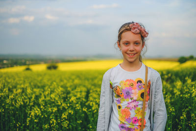 Portrait of smiling girl standing on field