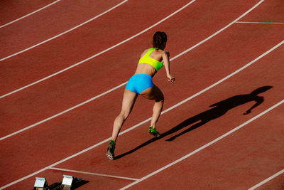 Full length of woman running on race track