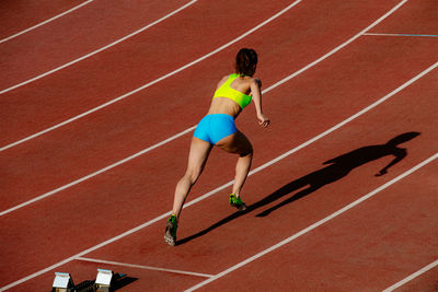 Full length of woman running on race track