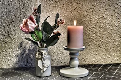 Close-up of flower vase on table against wall