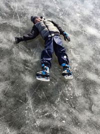 Full length of boy lying on ice rink