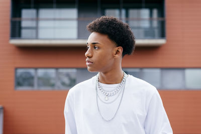 Portrait of young man looking away outdoors