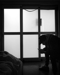 Side view of man sitting at home