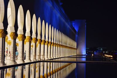 Reflection of illuminated buildings in city at night, sheikh zayed grand mosque center