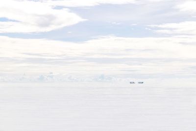 Airplane flying over sea against sky