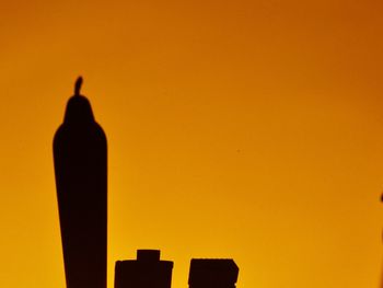 Close-up of silhouette bird against orange sky