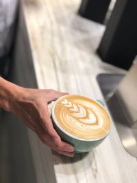 Woman holding coffee cup on table