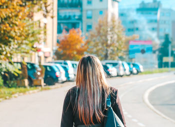 Rear view of woman walking on street in city