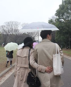 Rear view of man standing on footpath