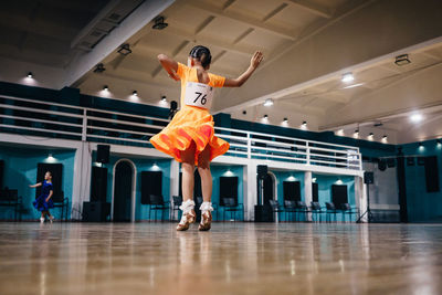 Girl in an orange ballroom dancing dress