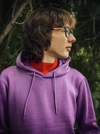 Portrait of young man standing against plants