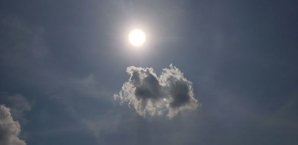 Low angle view of sun in sky during sunny day