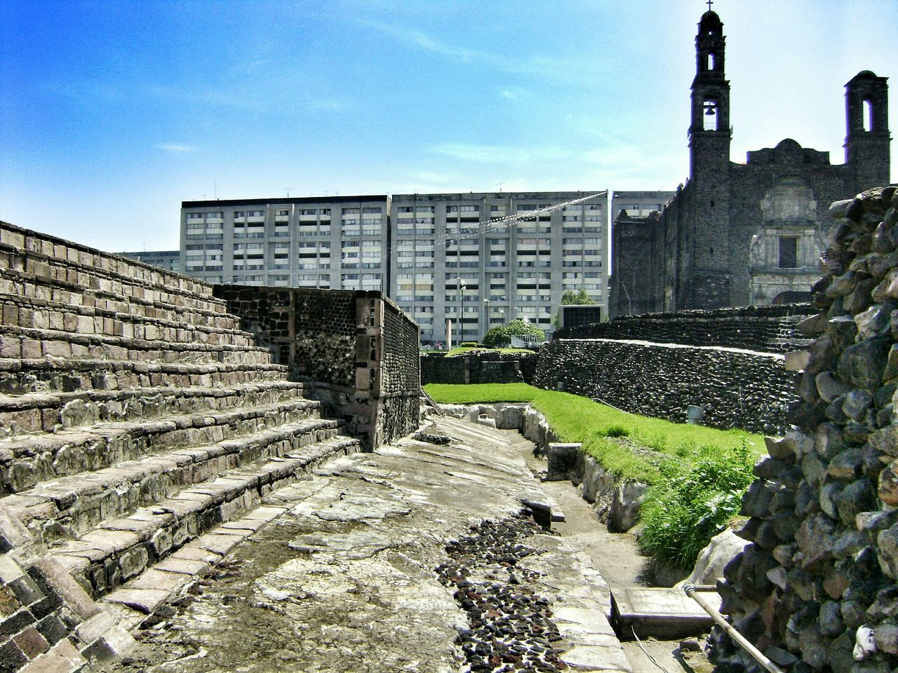 building exterior, architecture, built structure, sky, history, stone wall, day, tower, travel destinations, famous place, outdoors, stone material, no people, city, the past, religion, cloud - sky, stone - object, sunlight, incidental people